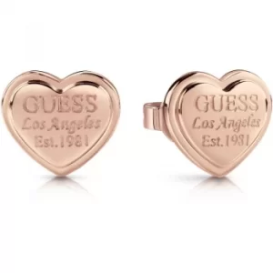 Image of GUESS rose gold plated heart-shaped stud earrings with engraved logo.