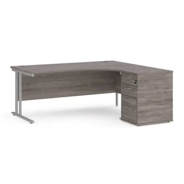 Image of Maestro 25 right hand ergonomic desk 1800mm with silver cantilever frame and desk high pedestal - grey oak