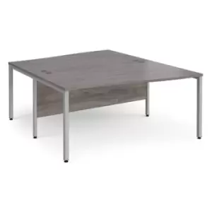Image of Maestro 25 back to back wave desks 1600mm deep - silver bench leg frame and grey oak top